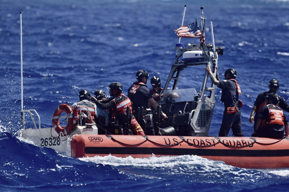 This photo provided by the U.S. Coast Guard, the crew of USCGC Oliver Henry (WPC 1140), rescues three mariners that were stranded on Pikelot Atoll, Yap State, Federated States of Micronesia, on April 9, 2024. The stranded mariners spelled out “HELP” with palm fronds on a beach that were spotted by Coast Guard and Navy aviators, the sign pinpointed them in a search area spanning thousands of square miles. (U.S. Coast Guard photo)