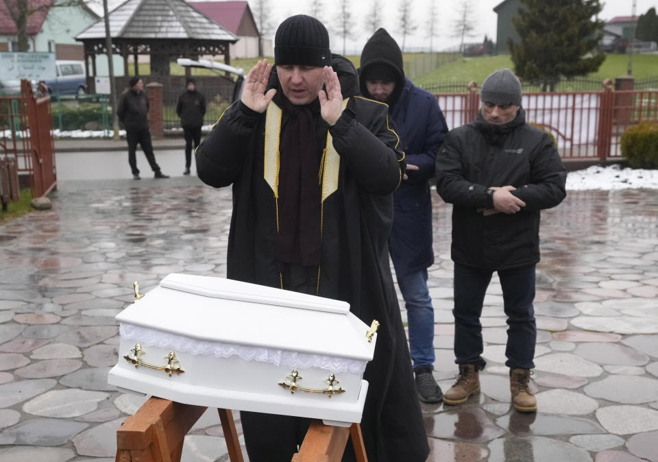 A Polish imam, left, and two other members of a Muslim community bury the tiny white casket of an unborn Iraqi boy, in Bohoniki, Poland, on Tuesday Nov. 23, 2021. The child is the latest life claimed as thousands of migrants from the Middle East have sought to enter the European Union but found their path cut off by a military build-up and fast approaching winter in the forests of Poland and Belarus. (AP Photo/Czarek Sokolowski)