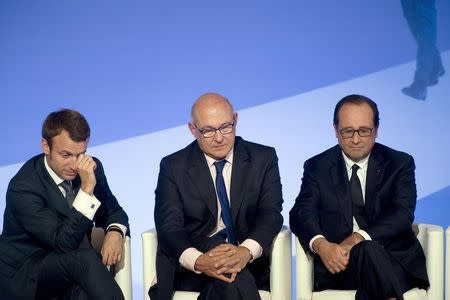 French President Francois Hollande (R), Finance Minister Michel Sapin (C) and French Economy and Industry Minister Emmanuel Macron (L) take part in the assizes for financing and investment at the Elysee Palace in Paris, September 15, 2014. REUTERS/Alain Jocard/Pool