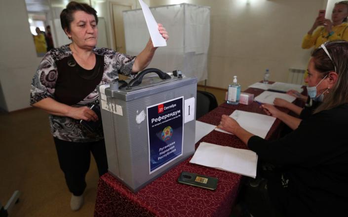 A woman from Luhansk region, the territory controlled by a pro-Russia separatist government, but who lives in Russia, votes at temporary accommodation facility in Volgograd, Russia