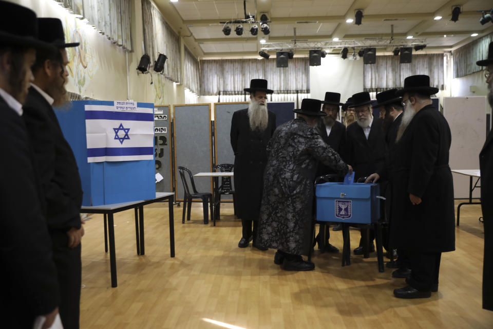 FILE - In this Tuesday, Sept. 17, 2019 file photo, ultra-Orthodox Jews watch Rabbi Israel Hager vote in Bnei Brak, Israel. In Israel's secular heartland, the role of religion in daily life played a central role in this week's deadlocked election. Prime Minister Benjamin Netanyahu’s tight alliance with the ultra-Orthodox may have contributed to his second-place finish. (AP Photo/Oded Balilty, File)