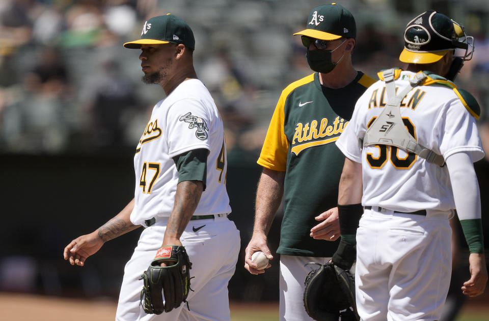 Oakland Athletics starting pitcher Frankie Montas (47) is taken out by Bob Melvin, center, during the sixth inning of a baseball game against the Tampa Bay Rays, Saturday, May 8, 2021, in Oakland, Calif. (AP Photo/Tony Avelar)