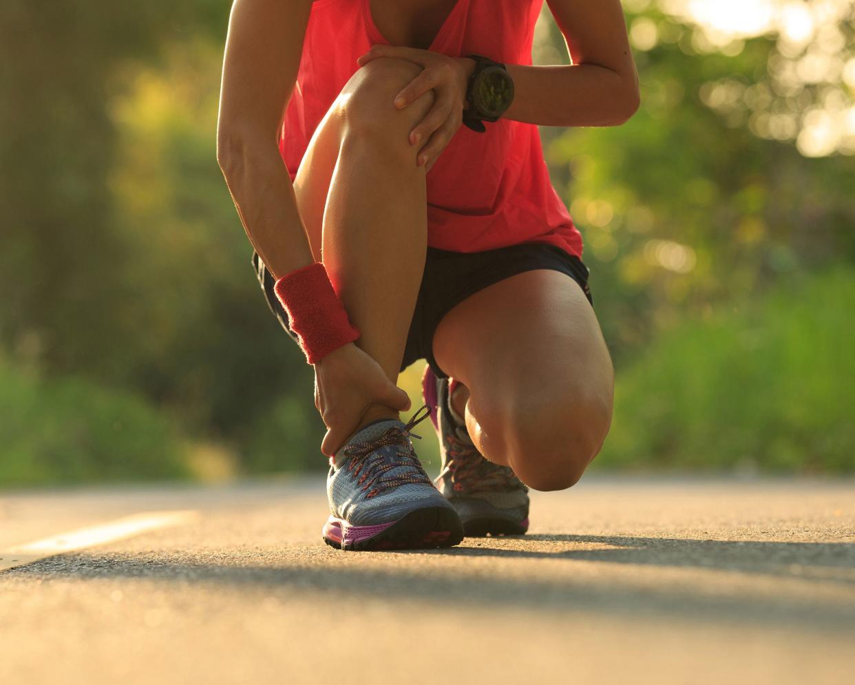 young fitness woman runner got sports injury in ankle