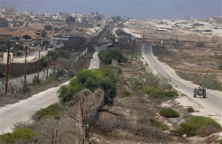 A Palestinian man drives on the border between Egypt and the southern Gaza Strip September 3, 2013. REUTERS/Ibraheem Abu Mustafa