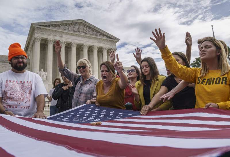 一群基督教福音派人士在最高法院外，國旗上擺著塑膠胚胎模型以強調反墮胎立場。（AP）