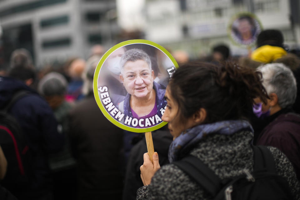 A woman holds up photographs of Turkish Medical Association President Dr. Sebnem Korur Fincanci, that reads in Turkish: "Freedom for Sebnem", during a small rally in her support outside the Justice court in Istanbul, Turkey, Wednesday, Jan. 11, 2023. A court convicted the president of the Turkish Medical Association on Wednesday of disseminating "terror organization propaganda" following a trial that human rights groups had denounced as an attempt to silence government critics. (AP Photo/Francisco Seco)