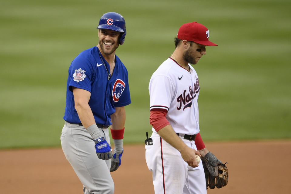 Chicago Cubs' Patrick Wisdom, left, reacts toward the dugout after he reached third on a fielding error by Washington Nationals right fielder Juan Soto (not shown) during the first inning of a baseball game, Saturday, July 31, 2021, in Washington. Nationals third baseman Carter Kieboom, right, looks on. (AP Photo/Nick Wass)