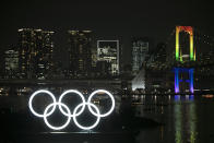 The illuminated Olympic rings float in the water near the Rainbow Bridge during a ceremony held to celebrate the 6-months-to-go milestone for the Tokyo 2020 Olympics Friday, Jan. 24, 2020, in the Odaiba district of Tokyo. (AP Photo/Jae C. Hong)