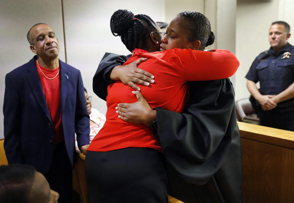 State District Judge Tammy Kemp, right, gives Botham Jean's mother, Allison Jean, a hug while Botham's father, Bertrum Jean, stands at left, following the 10-year sentence given to former Dallas Police Officer Amber Guyger for murder, Wednesday, Oct. 2, 2019, in Dallas. Guyger, who said she mistook neighbor Botham Jean's apartment for her own and fatally shot him in his living room, was sentenced to a decade in prison. (Tom Fox/The Dallas Morning News via AP, Pool)