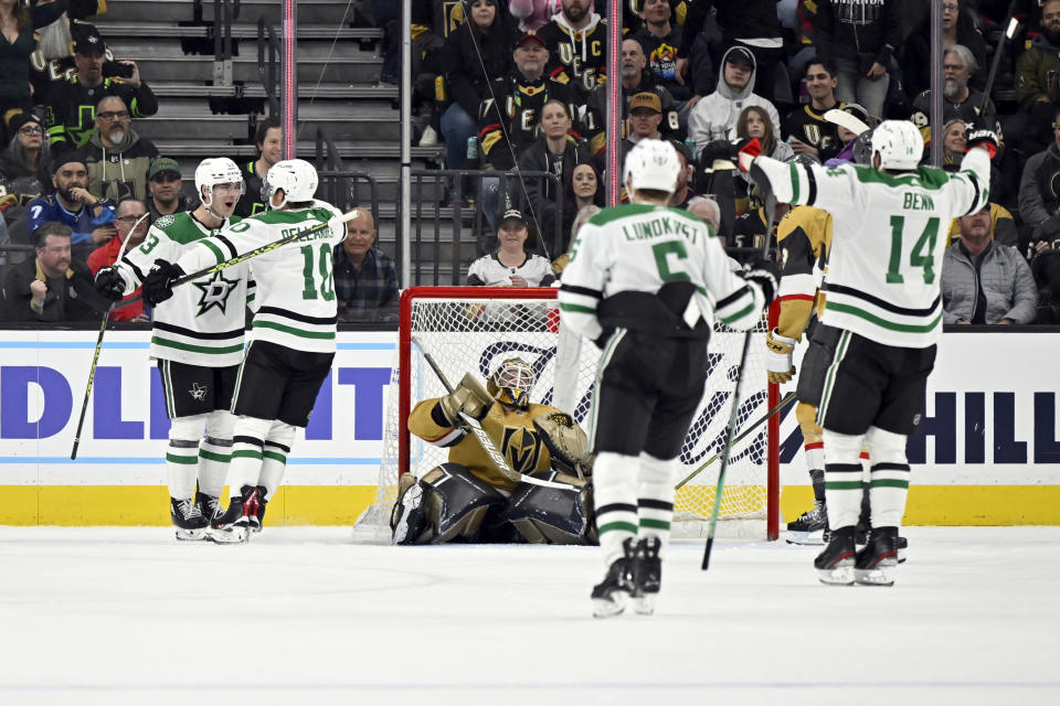 Dallas Stars center Wyatt Johnston, left, celebrates with center Ty Dellandrea (10) after scoring against Vegas Golden Knights goaltender Laurent Brossoit, center, during the second period of an NHL hockey game Saturday, Feb. 25, 2023, in Las Vegas. (AP Photo/David Becker)