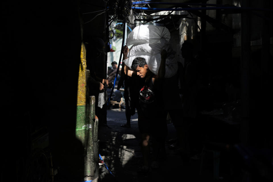 A man delivers a sack of ice cubes as demand remains high due to hot weather in Quezon city, Philippines on Wednesday, April 24, 2024. (AP Photo/Aaron Favila)