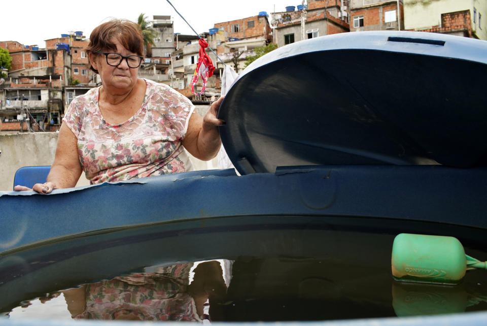 Laura Maria de Almeida shows her home's water storage container, full of cloudy, smelly water, on her roof in the Complexo de Alemao slum of Rio de Janeiro, Brazil, Thursday, Jan.16, 2020. De Almeida said cloudy water isn't unusual in her community, but police are investigating workers at a state utility after smelly tap water flowed into dozens of neighborhoods of the Brazilian city. (AP Photo/Ricardo Borges)