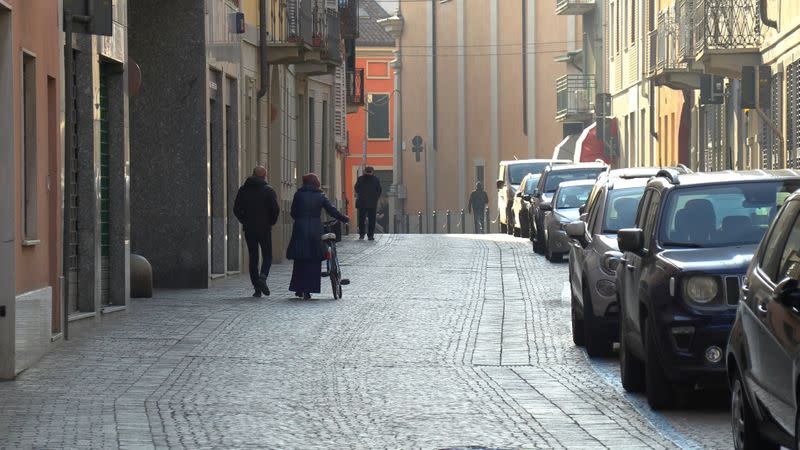 People walk down an empty street in the village of Codogno after officials told residents to stay home and suspend public activities as 14 cases of coronavirus are confirmed in northern Italy