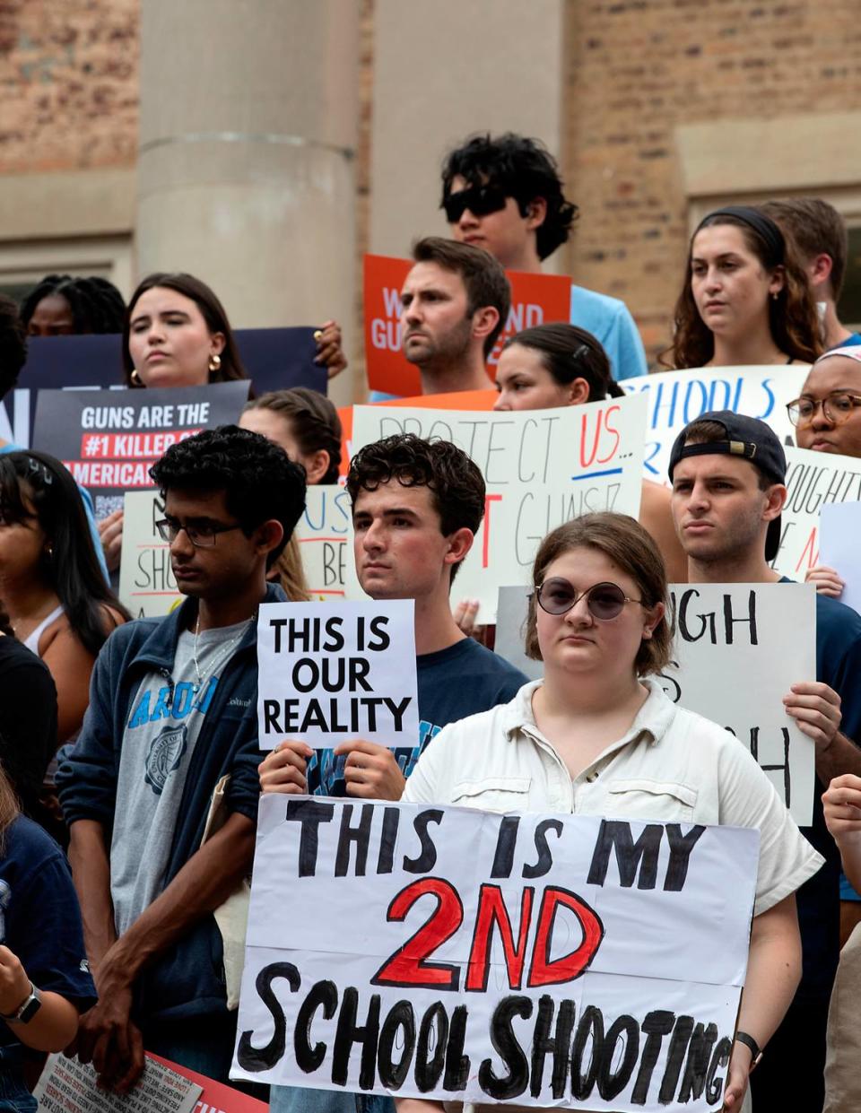 People hold signs during a student-led rally at UNC-Chapel Hill in support of gun control on Wednesday, Aug. 30, 2023. A graduate student has been charged with first-degree murder following a Monday shooting that left physics professor Zijie Yan dead on the university’s campus.