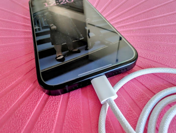 iPhone 15 Pro in Titanblau mit dem mitgelieferten USB-C-Kabel.