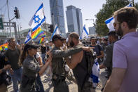 Israeli police officer argues with a demonstrator as others blockןמע a main road to protest against plans by Prime Minister Benjamin Netanyahu's new government to overhaul the judicial system, in Tel Aviv, Israel, Wednesday, March 1, 2023. (AP Photo/Oded Balilty)