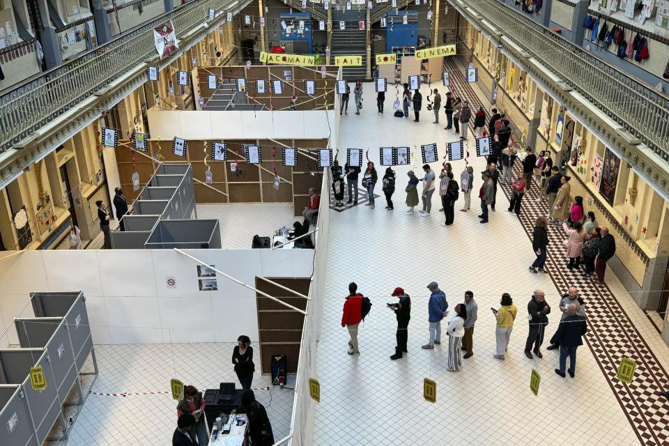 People line up to vote at a school in Brussels, Sunday, June 9, 2024. Polling stations opened across Europe on Sunday as voters from 20 countries cast ballots in elections that are expected to shift the European Union's parliament to the right and could reshape the future direction of the world's biggest trading bloc. (AP Photo/Sylvain Plazy)