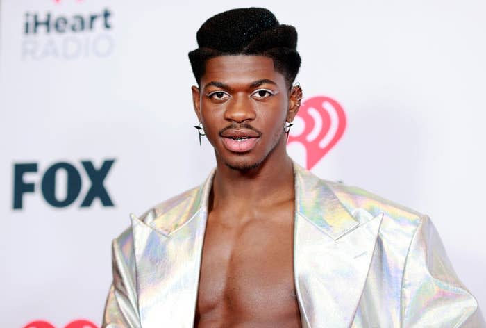 Lil Nas at a red carpet event in a mettalic suit