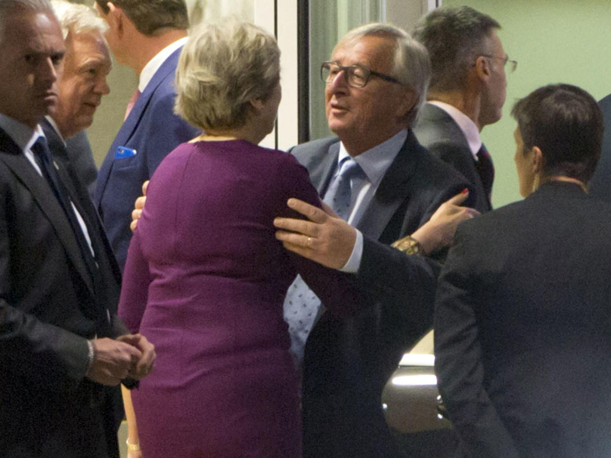 Jean-Claude Juncker embraces Theresa May as David Davis looks on: AP