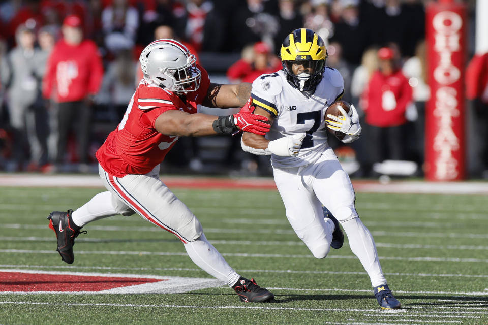 Ohio State defensive lineman Ty Hamilton, left, tackles Michigan running back Donovan Edwards during the second half of an NCAA college football game on Saturday, Nov. 26, 2022, in Columbus, Ohio. (AP Photo/Jay LaPrete)