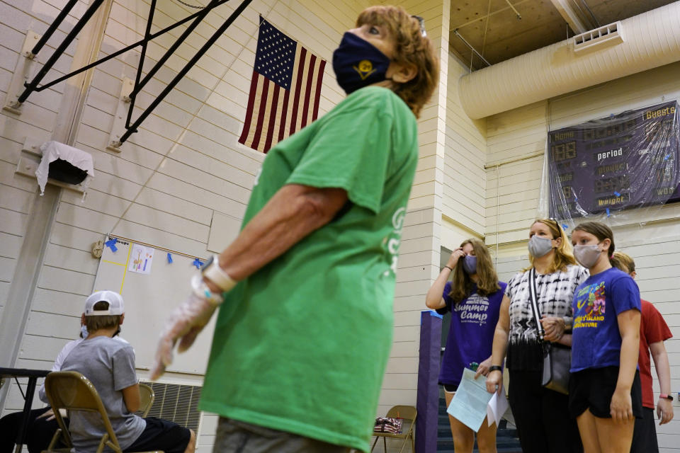 Students and parents wear mask as they wait to receive a second dose of the Pfizer COVID-19 vaccine during a vaccination clinic hosted by Jewel Osco at London Middle School in Wheeling, Ill., Friday, June 11, 2021. After nearly 15 months of shutdowns, limited capacity and sheltering at home, the State of Illinois, including Chicago, fully reopened today. Businesses still can have their own rules for capacity, masks and social distancing. Masks are still required on public transportation and in airports, schools and hospitals. (AP Photo/Nam Y. Huh)