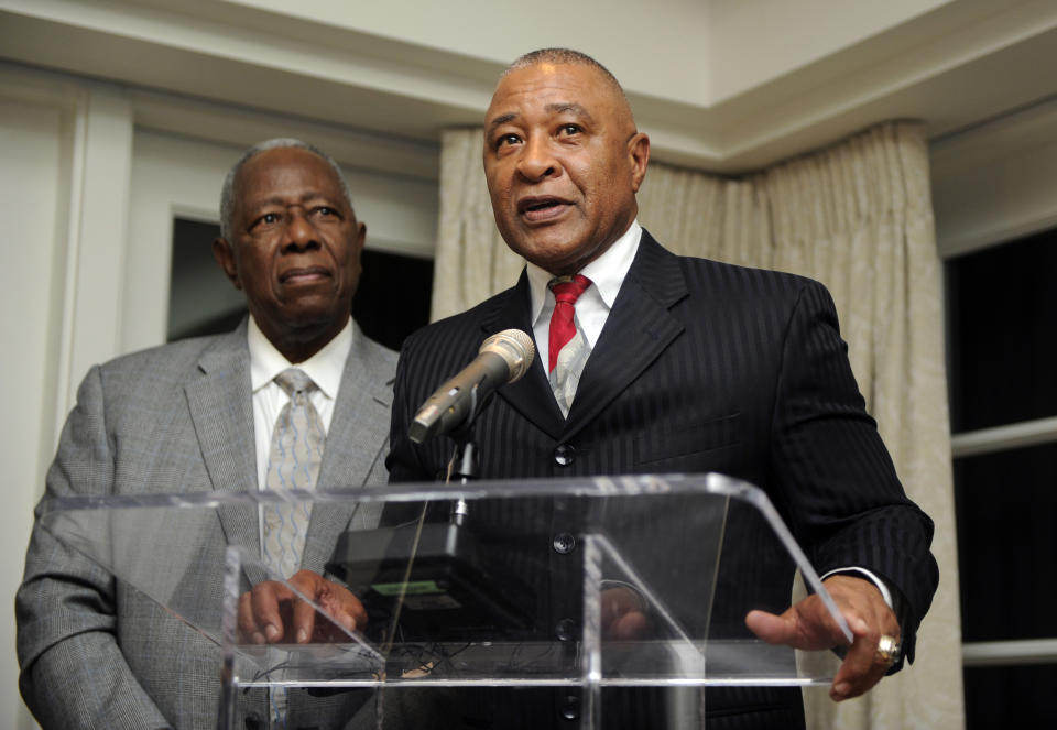 Baseball Hall of Famer Hank Aaron, left, listens as fellow Hall of Famer Ozzie Smith, right, speaks at a reception for Aaron, Friday, Feb. 7, 2014, in Washington. Aaron turned 80 this weekand is being celebrated with a series of events in Washington. (AP Photo/Nick Wass)