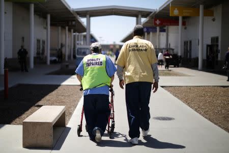 A Gold Coat inmate helps another inmate walk to a medical appointment at the California Health Care Facility in Stockton, California, U.S., May 24, 2018. REUTERS/Lucy Nicholson