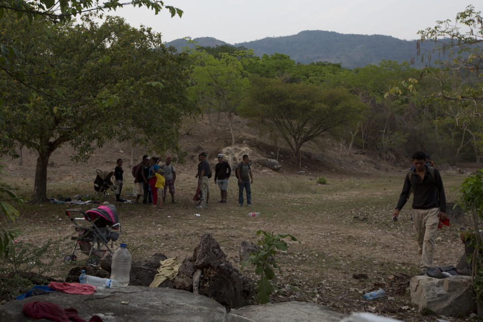 Migrantes centroamericanos reunidos a un lado de la carretera, en la zona donde agentes mexicanos de inmigración detuvieron antes ese día a otros migrantes, mientras recuperan las pertenencias que dejaron caer para huir y charlan sobre cómo continuar su camino, junto a la autopista en Pijijiapan, en el estado mexicano de Chiapas, el lunes 22 de abril de 2019. (AP Foto/Moisés Castillo)