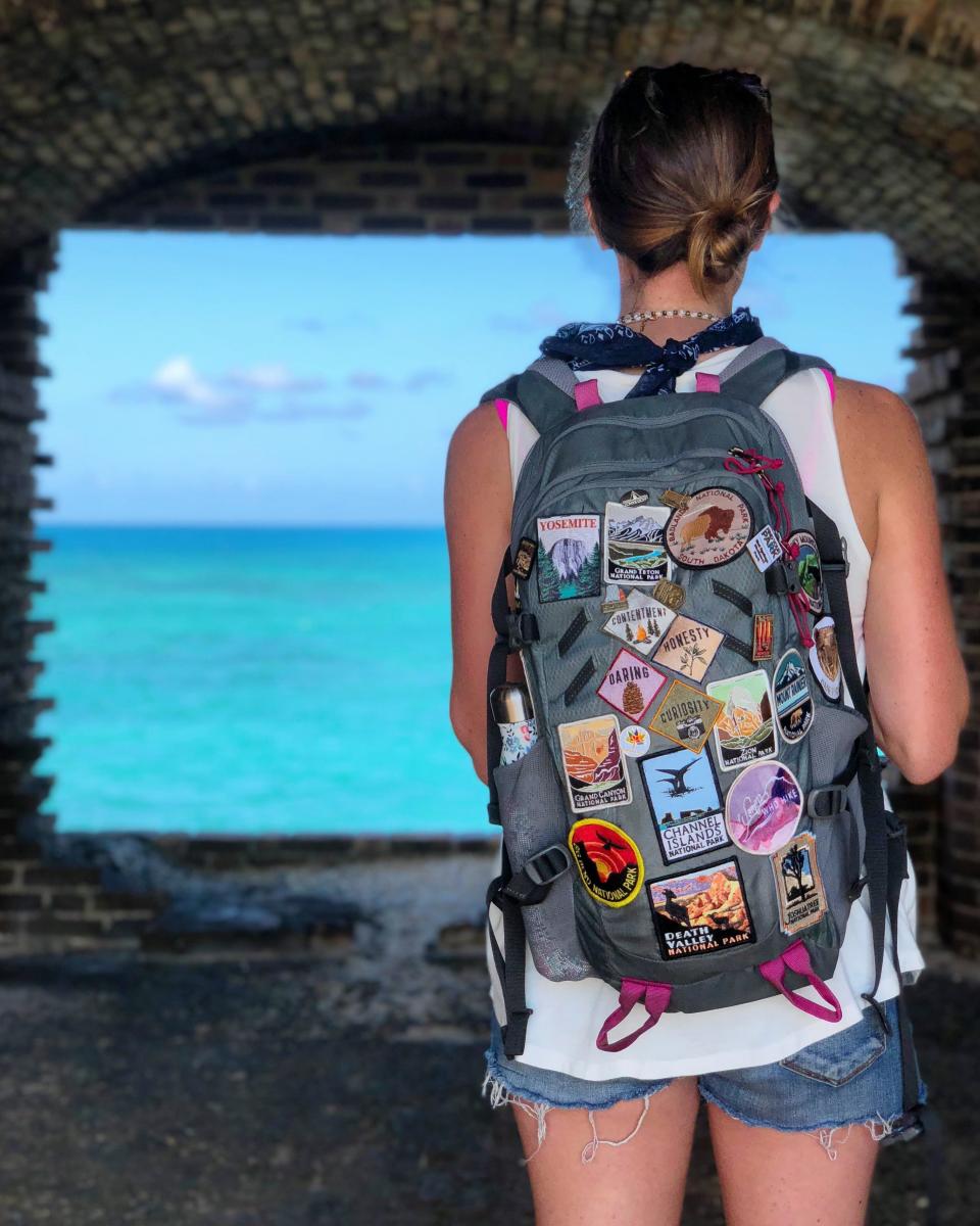 A woman with a backpack looking out at the water at Dry Tortugas National Park.