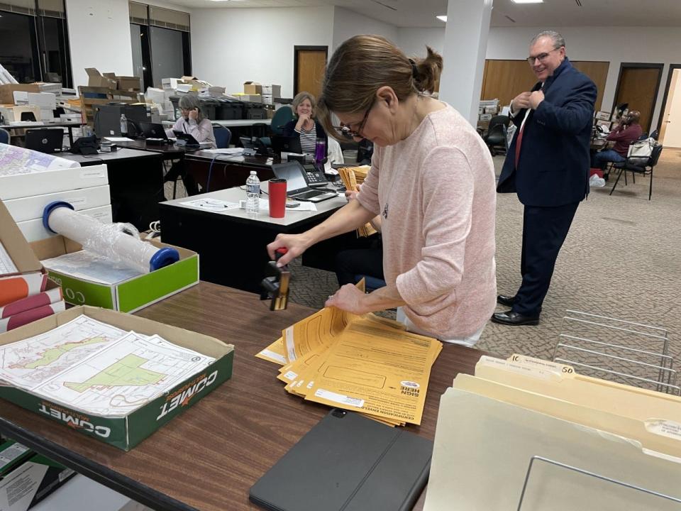 Mary Roth puts a stamp on mail ballots for the consolidated elections as Sangamon County Clerk Don Gray looks on Tuesday April 4, 2023.