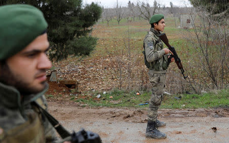 Members of Turkey-backed Free Syrian Army police forces secure the road as they escort a convoy near Azaz, Syria January 26, 2018. REUTERS/Umit Bektas