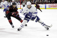 Toronto Maple Leafs center Alexander Kerfoot (15) and Carolina Hurricanes center Jesperi Kotkaniemi (82) chase the puck during the second period of an NHL hockey game Saturday, March 25, 2023, in Raleigh, N.C. (AP Photo/Chris Seward)