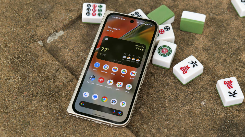 Off angle shot of the Pixel 9 Pro Fold laying on a bunch of mahjong tiles on a park table.