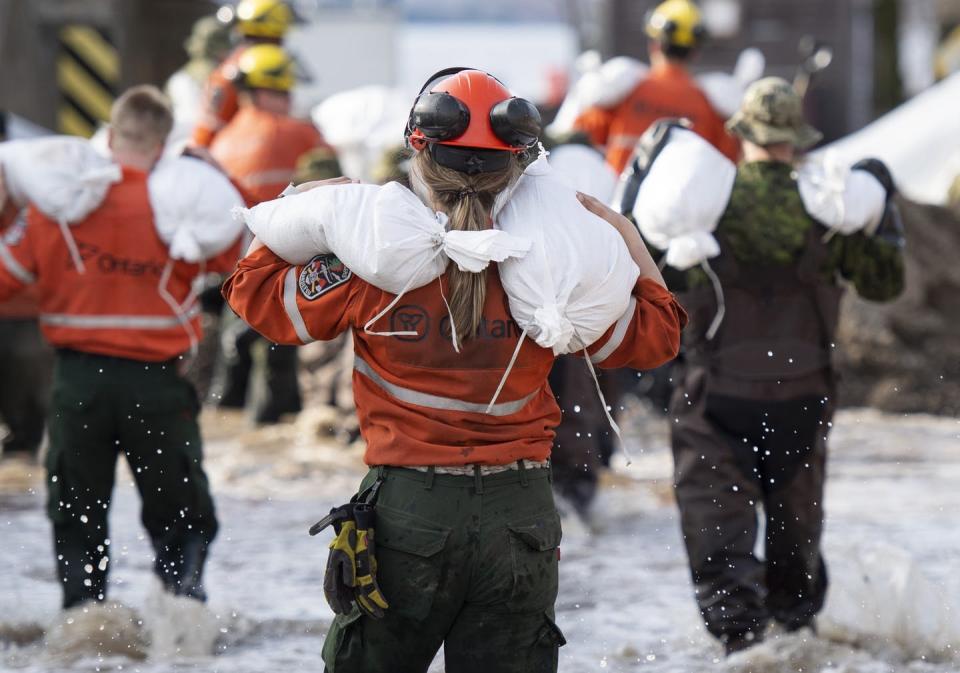 <span class="caption">Ontario fire rangers carry sandbags to fortify a wall holding back floodwaters in Pembroke, Ont., in May 2019.</span> <span class="attribution"><span class="source">THE CANADIAN PRESS/Justin Tang</span></span>