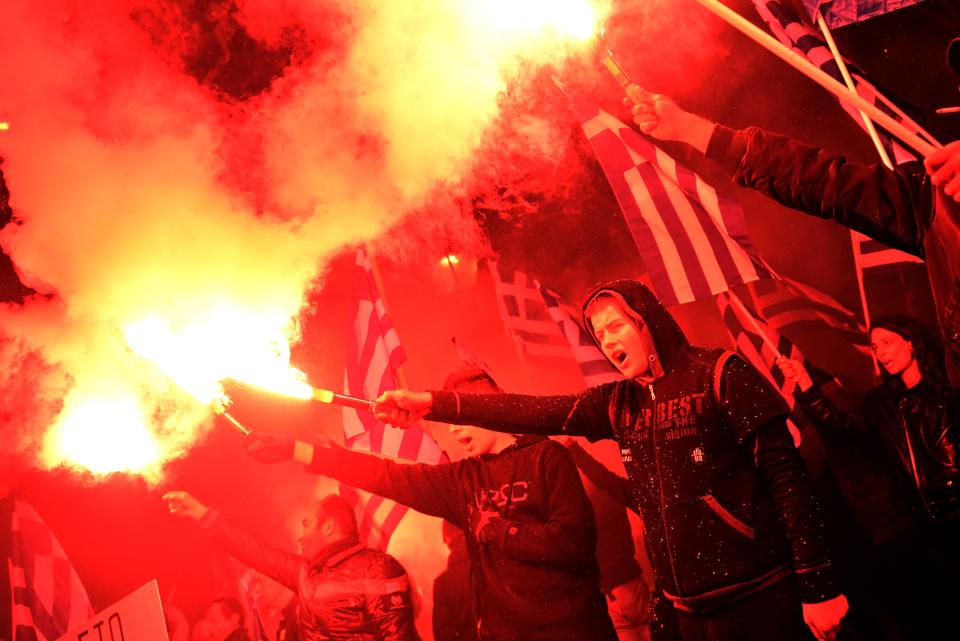 Members of the ultra nationalist party Golden Dawn chant the Greek national anthem outside the German embassy in Athens on March 22, 2013. (ARIS MESSINIS/AFP/Getty Images)