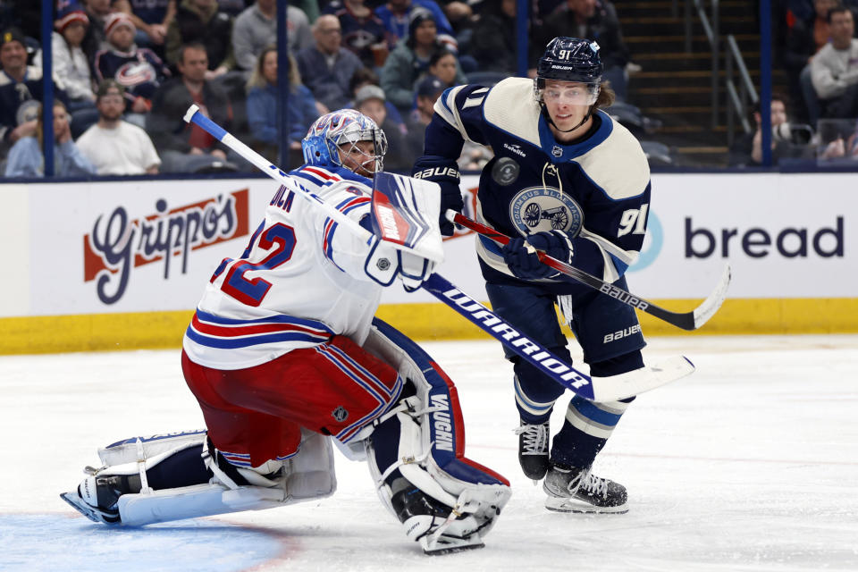 New York Rangers goalie Jonathan Quick, left, makes a stop in front of Columbus Blue Jackets forward Kent Johnson during the second period of an NHL hockey game in Columbus, Ohio, Sunday, Feb. 25, 2024. (AP Photo/Paul Vernon)