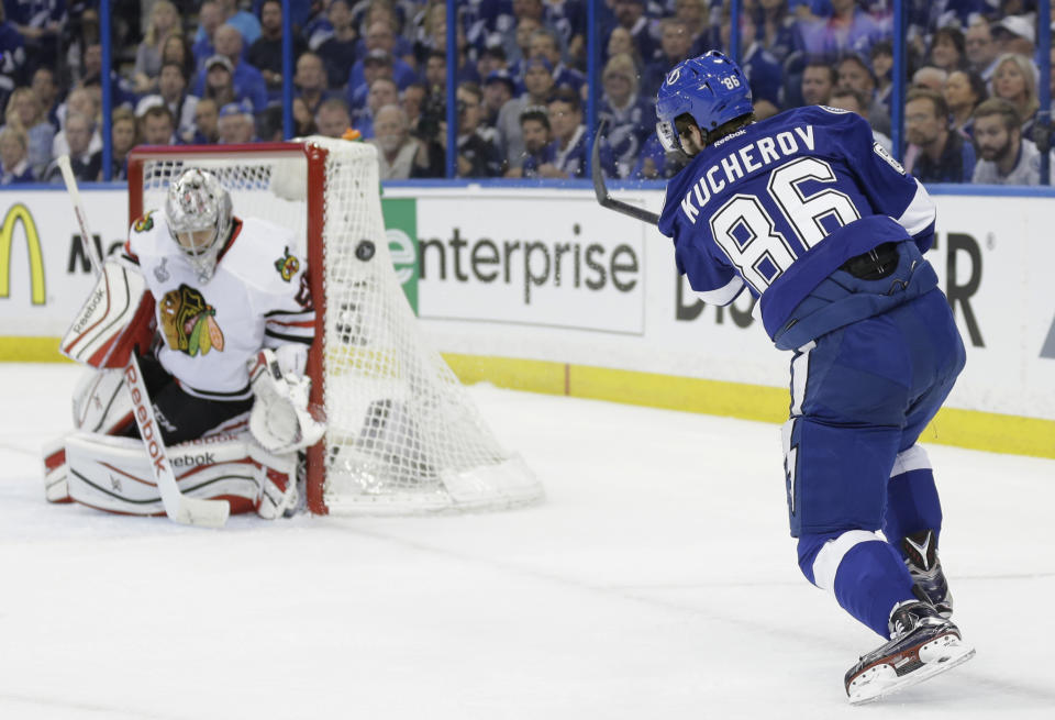 Chicago Blackhawks goalie Corey Crawford (50), left, blocks a shot by Tampa Bay Lightning right wing Nikita Kucherov (86), during the first period in Game 1 of the NHL hockey Stanley Cup Final in Tampa, Fla., Wednesday, June 3, 2015. (AP Photo/Chris O&#39;Meara)