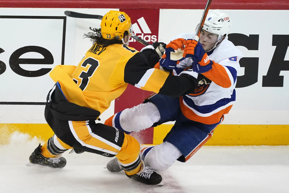 Pittsburgh Penguins' Brandon Tanev, left, checks New York Islanders' Noah Dobson off his skates during the first period in Game 1 of an NHL hockey Stanley Cup first-round playoff series in Pittsburgh, Sunday, May 16, 2021. (AP Photo/Gene J. Puskar)