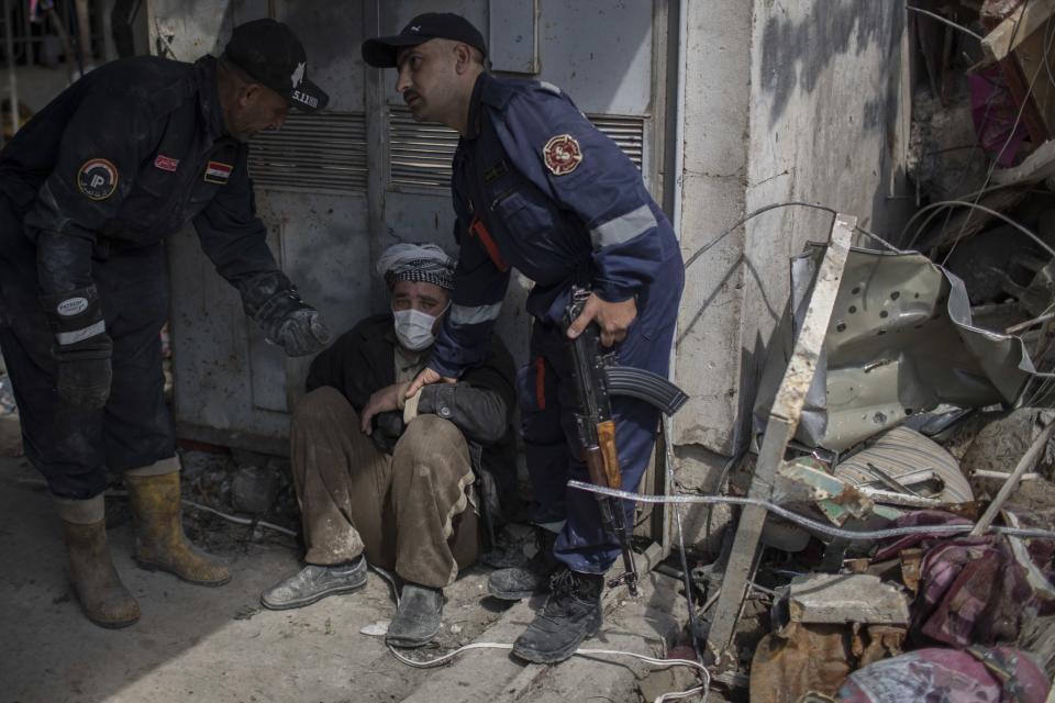 A man is helped after identifying the body of a relative who died in a house that was destroyed during fights between Iraq security forces and the Islamic State. (Photo: Felipe Dana/AP)