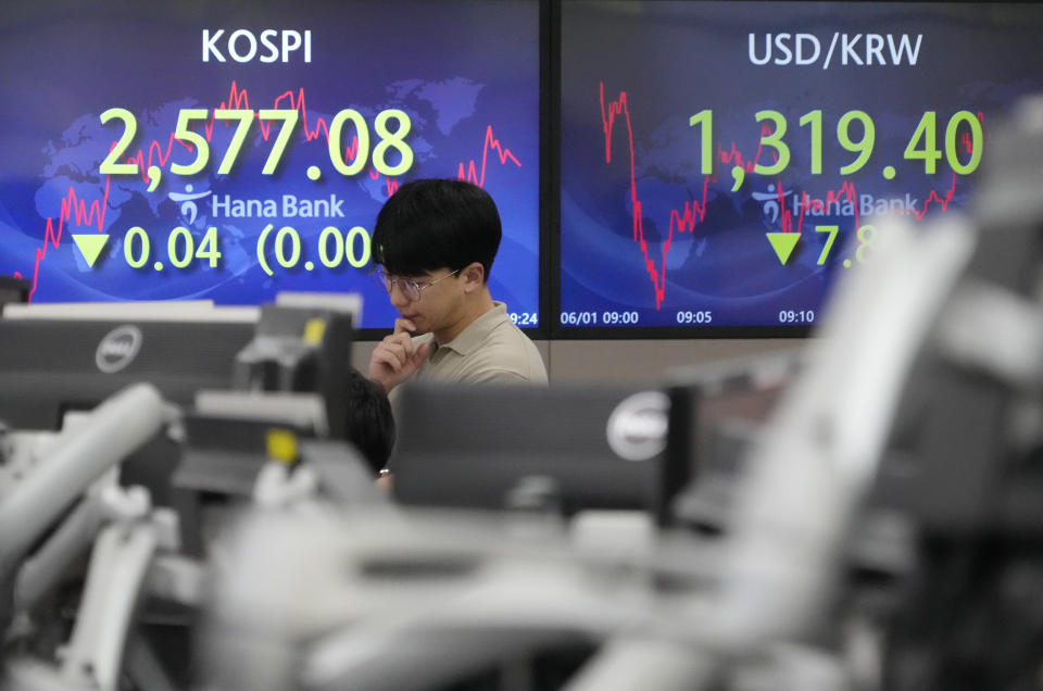 A currency trader watches monitors in front of screens showing the Korea Composite Stock Price Index (KOSPI), top left, and the foreign exchange rate between U.S. dollar and South Korean won at the foreign exchange dealing room of the KEB Hana Bank headquarters in Seoul, South Korea, Thursday, June 1, 2023. Asian benchmarks were mostly higher Thursday after the U.S. House of Representatives approved a debt ceiling and budget cuts package, avoiding a default crisis. (AP Photo/Ahn Young-joon)