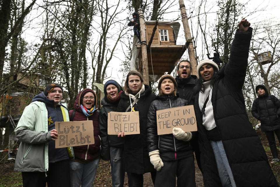 Climate activists Greta Thunberg, front third right, and Luisa Neubauer, front center, visit the village Luetzerath near Erkelenz, Germany, Friday, Jan. 13, 2023. The energy company RWE wants to excavate the coal lying under Luetzerath - for this purpose, the hamlet on the territory of the city of Erkelenz at the opencast lignite mine Garzweiler II is to be demolished. (Federico Gambarini/dpa via AP)