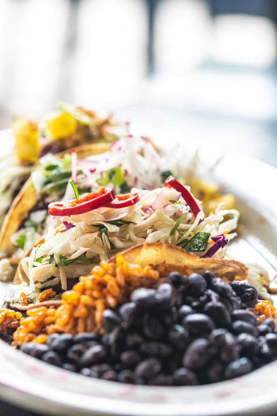 Tacos with a side of Mexican rice and black beans at El Camino are calling to you.