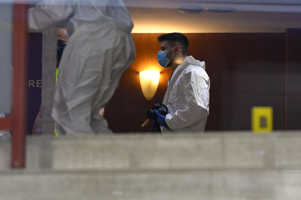 Forensic workers collect body parts and evidence from a hotel downtown Bucharest, Romania, Friday, June 19, 2020. Gholamreza Mansouri, a former judge from Iran sought by his country to face corruption charges has died after falling from a high floor inside a hotel. Romanian police said only that a man had fallen from a high floor at a hotel in Bucharest, the Romanian capital, and was found dead. (AP Photo/Andreea Alexandru)