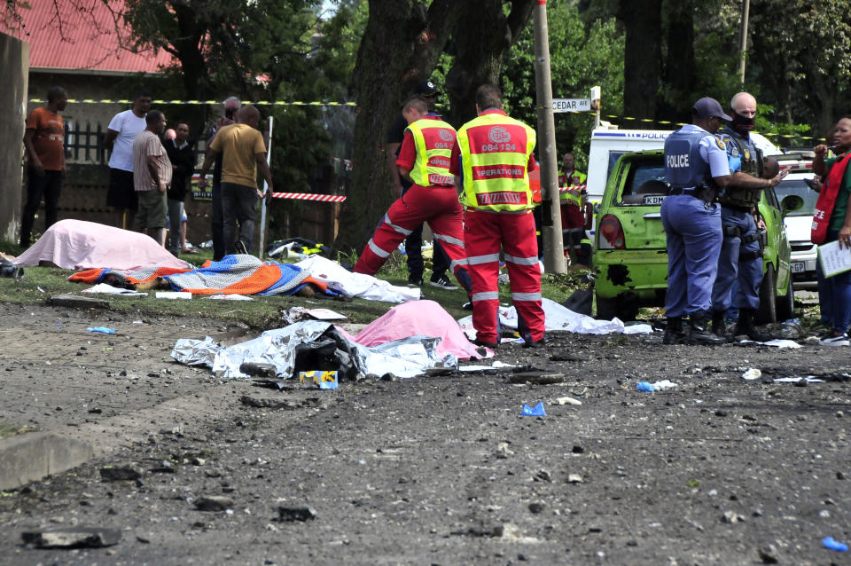 Bodies lay covered at the scene where a gas tanker exploded under a bridge in Boksburg, east of Johannesburg, Saturday, Dec. 24, 2022. A truck carrying liquified petroleum gas has exploded in the South African town of Boksburg, killing at least 8 people and injuring more than 50 others on Saturday. (AP Photo/Hein Kaiser)