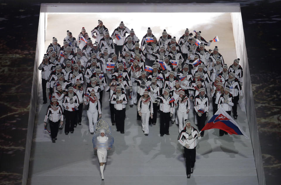 Tomaz Razingar of Slovenia holds his national flag and enters the arena with teammates during the opening ceremony of the 2014 Winter Olympics in Sochi, Russia, Friday, Feb. 7, 2014. (AP Photo/Charlie Riedel)