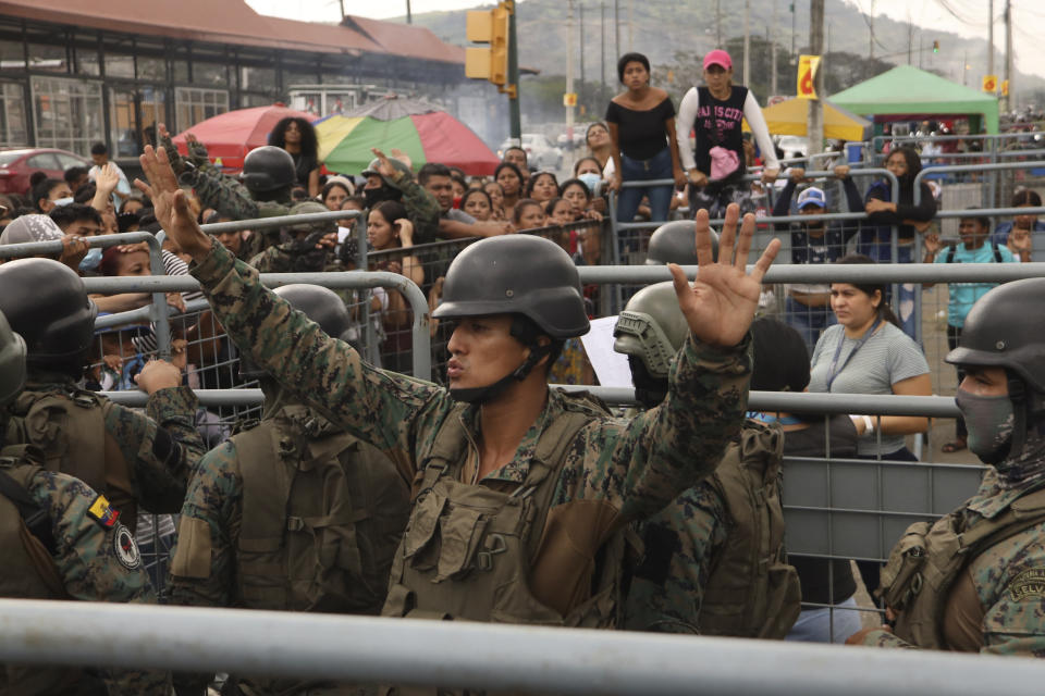 FILE - A soldier asks for calm from the friends and family members of inmates seeking information after deadly clashes at the Litoral Penitentiary, in Guayaquil, Ecuador, July 25, 2023. Ecuador announced a state of emergency in all of its prisons after a series of violent incidents including shootings and explosions occurred in one of its most dangerous prisons. (AP Photo/Cesar Munoz, File)