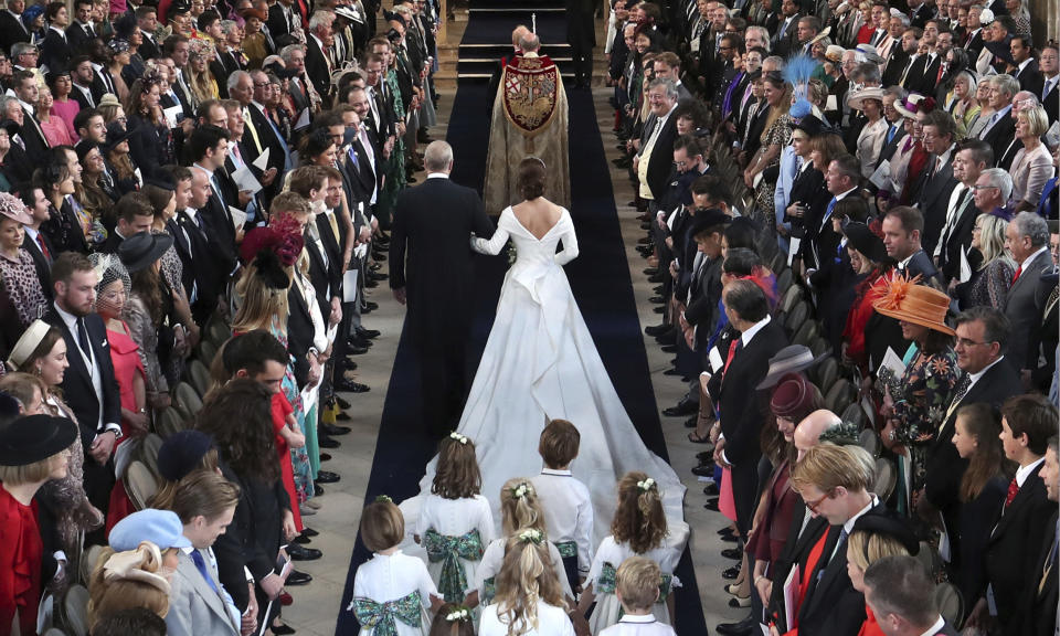 <p>Prinz Andrew führte seine Tochter in der St.-George’s-Kapelle zum Traualtar. Hier heirateten Prinz Harry und Meghan, Herzogin von Sussex, bereits im Mai dieses Jahres. Ihr cremefarbenes Kleid mit üppiger Schleppe ist von dem britischen Designerduo Peter Pilotto und Christopher De Vos. (Bild: Danny Lawson/Pool via AP) </p>