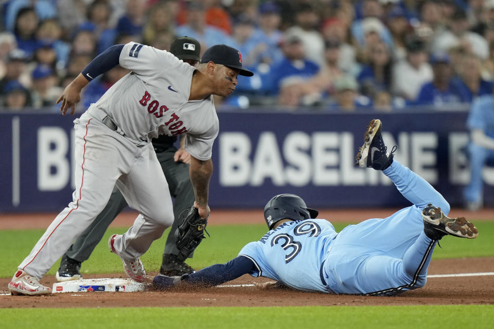 Toronto Blue Jays center fielder Kevin Kiermaier (39) slides safe into third on a steal as Boston Red Sox third baseman Rafael Devers looks on during the third inning of a baseball game in Toronto, Sunday, July 2, 2023. (Frank Gunn/The Canadian Press via AP)