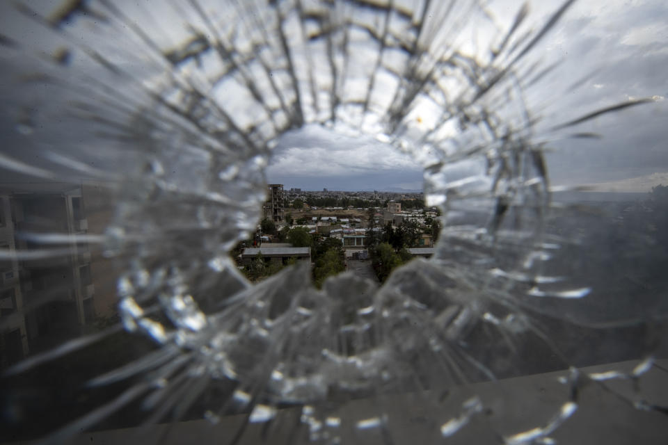 FILE - The city of Mekele is seen through a bullet hole in a stairway window of the Ayder Referral Hospital in the Tigray region of northern Ethiopia on May 6, 2021. The war in Africa's second most populous country has killed thousands of people and displaced millions. (AP Photo/Ben Curtis, File)