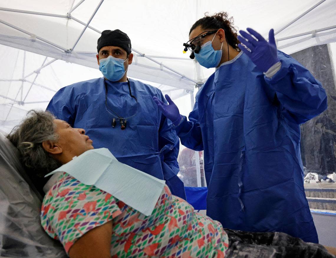 Fourth year dental students Carlos Andrade and Miguel Rangel talk to Gaby Gonzalez about her dental problems at the Remote Area Medical Clinic at the Southwestern Baptist Theological Seminary in Fort Worth on Saturday.